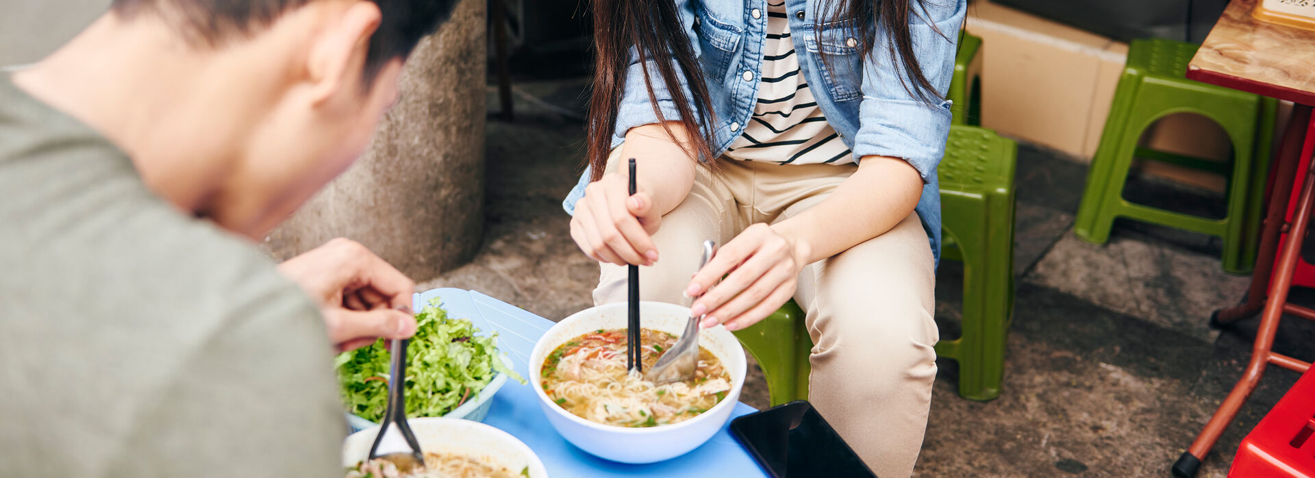 Couple enjoying a bowl of street food in Vietnam